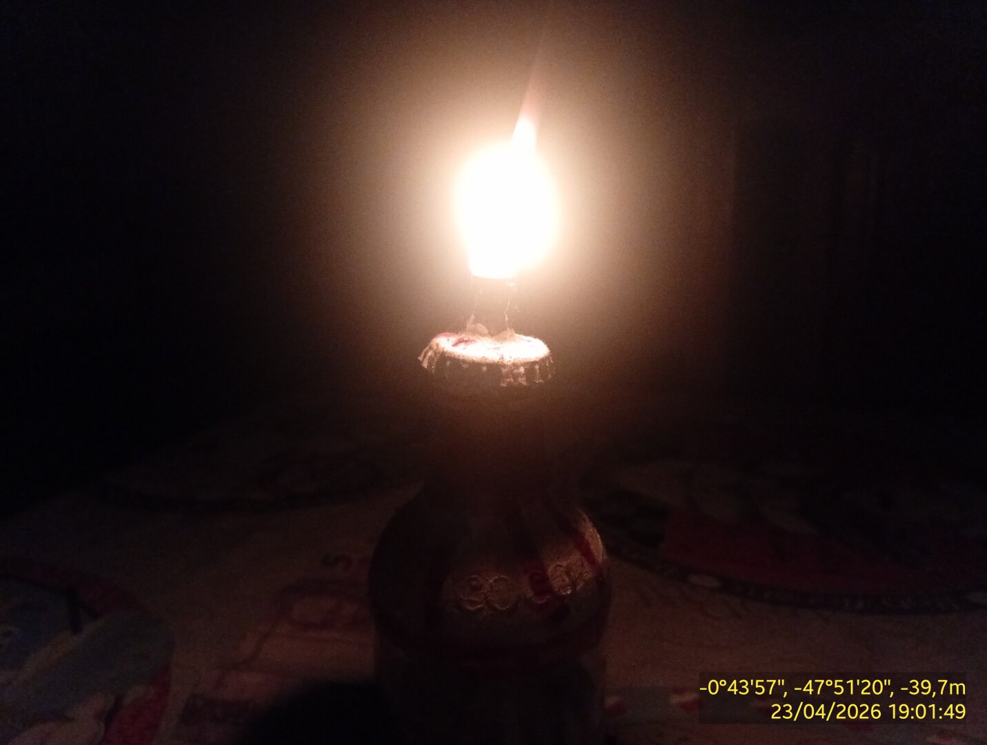 Uma lamparina caseira ilumina uma mesa