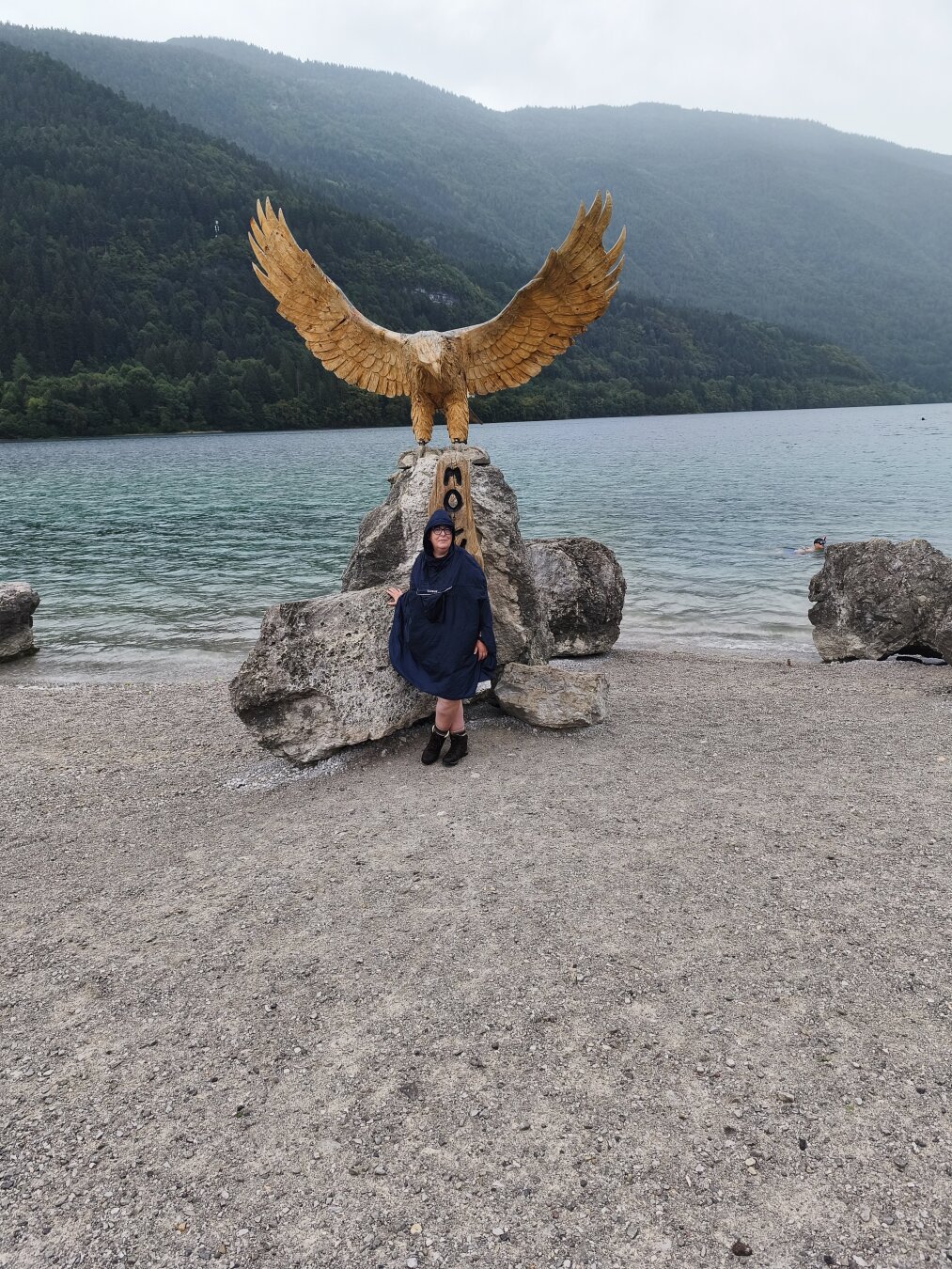Ich stehe in Regencape und Wanderstiefeln vor besagtem Adler.