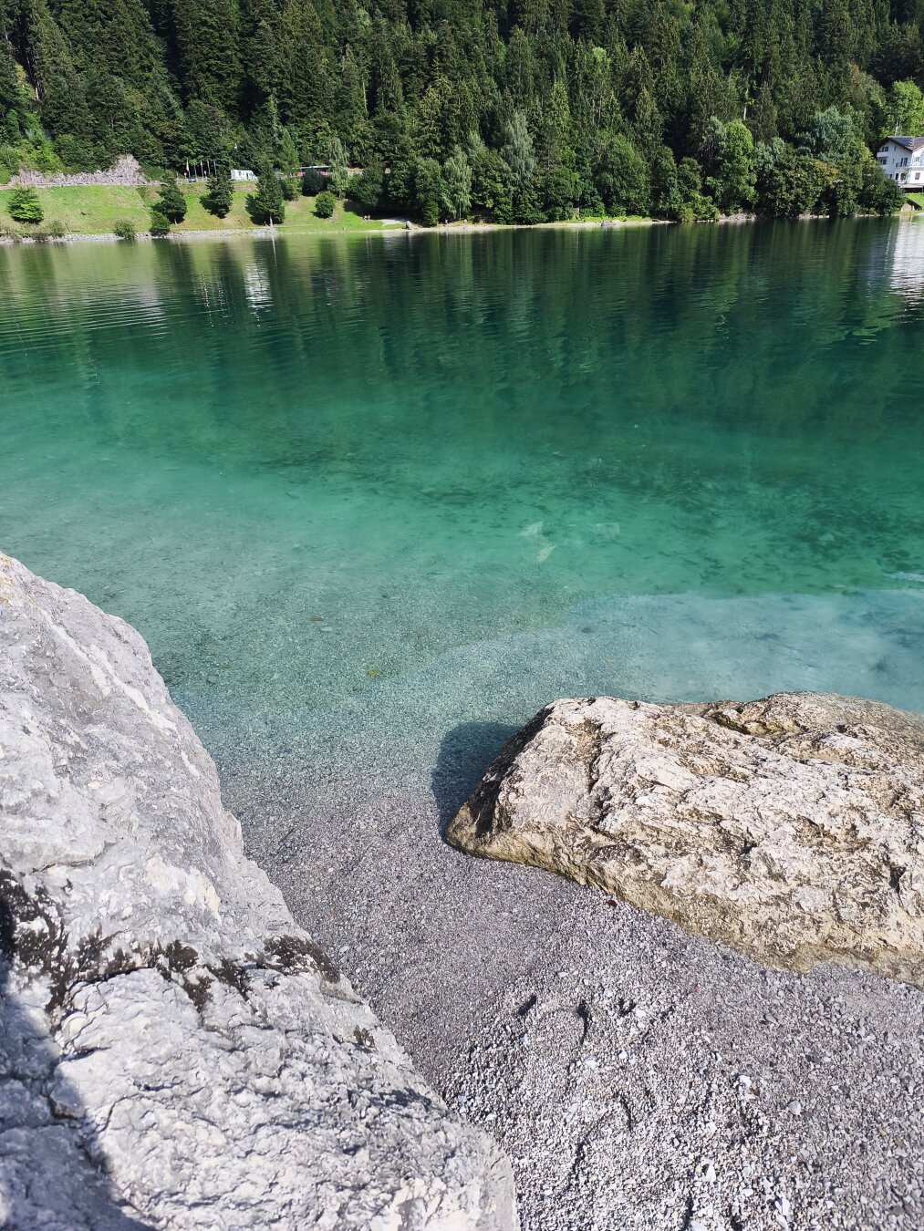 Türkisgrünes Wasser in einer kleinen Felsenbucht.