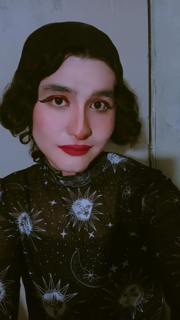 A selfie wearing a witchy star moon blouse and a black headscarf.