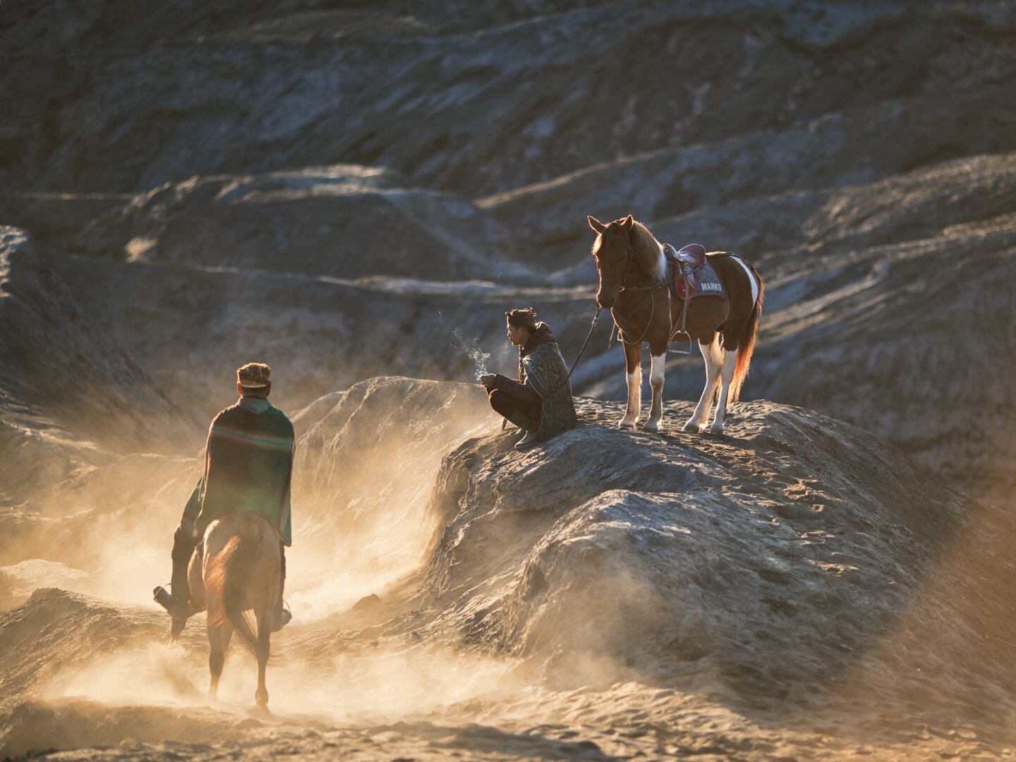 First horseman turns away, with the camera now focused on the squatting one. More volcanic landscape is visible in this shot as the sand settles a bit