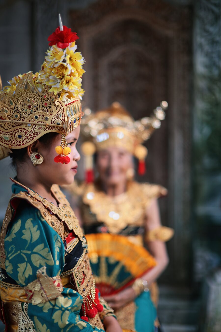 Focus shifts to the younger dancer with Niang shifting in background
