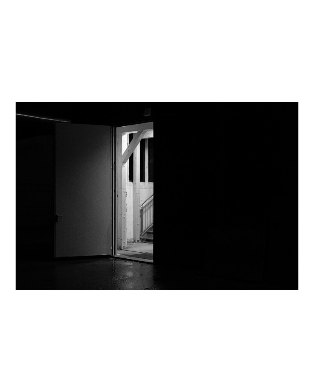 Open back door, light shines out, black and white, strong contrast.
