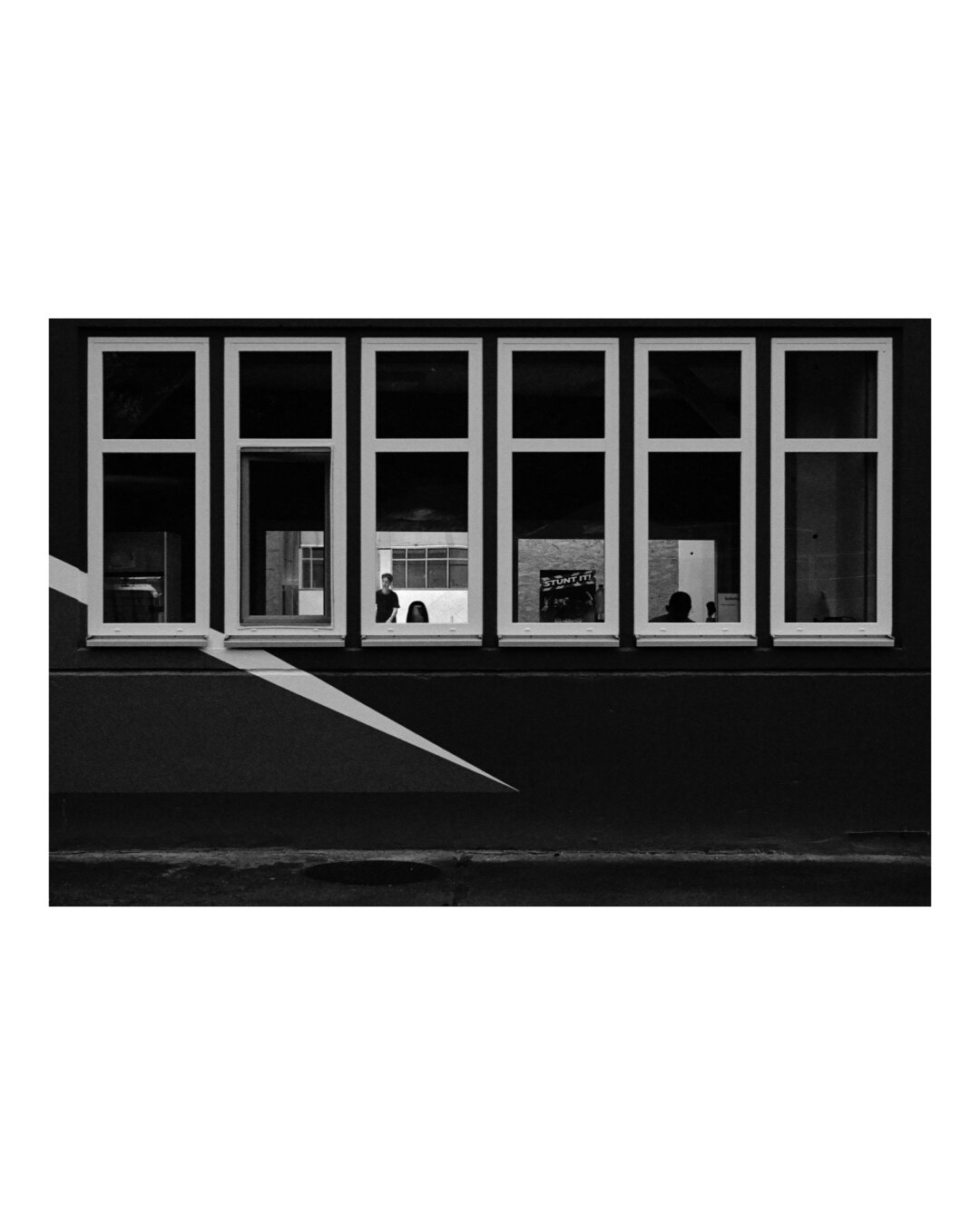 Large window, shot from outside, with looking direction into the the skate hall. Black and white, strong contrasts.