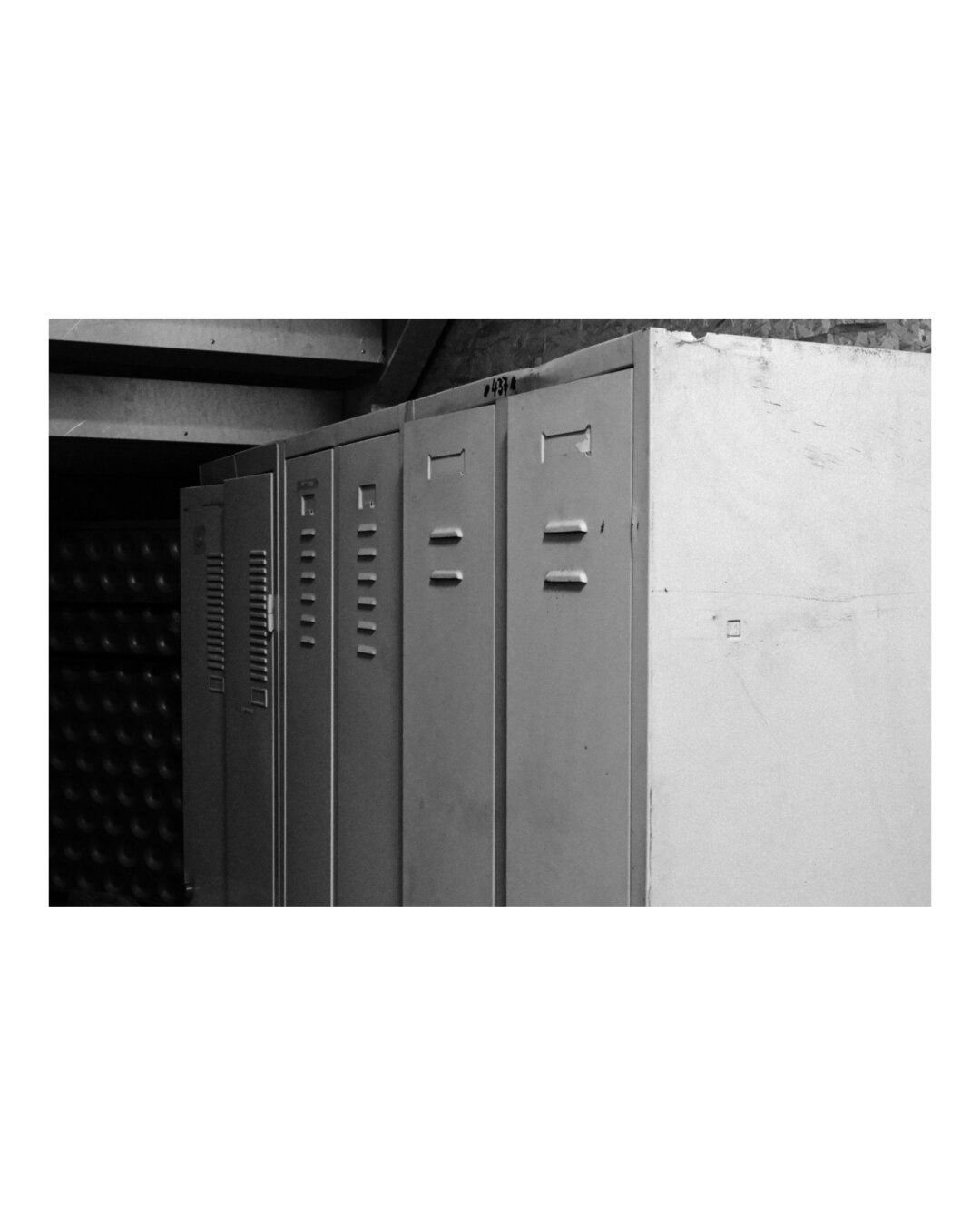 Row of steel lockers, black and white, strong contrast.