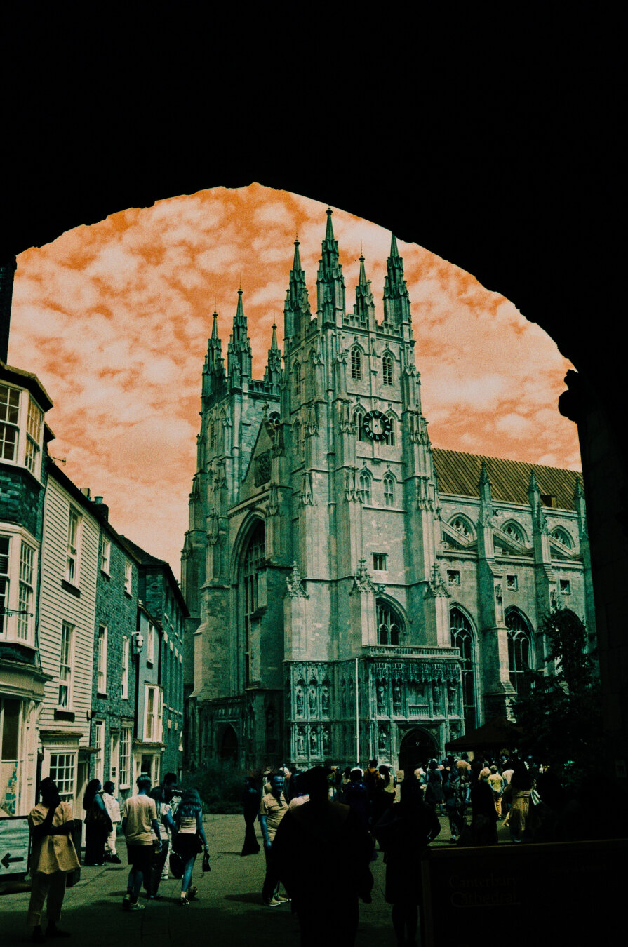 Analog color photo of Canterbury Cathedral. The photo was taken half way through an archway, which frames the tower of the cathedral. Colors are mixed up because of the turquoise film used.
