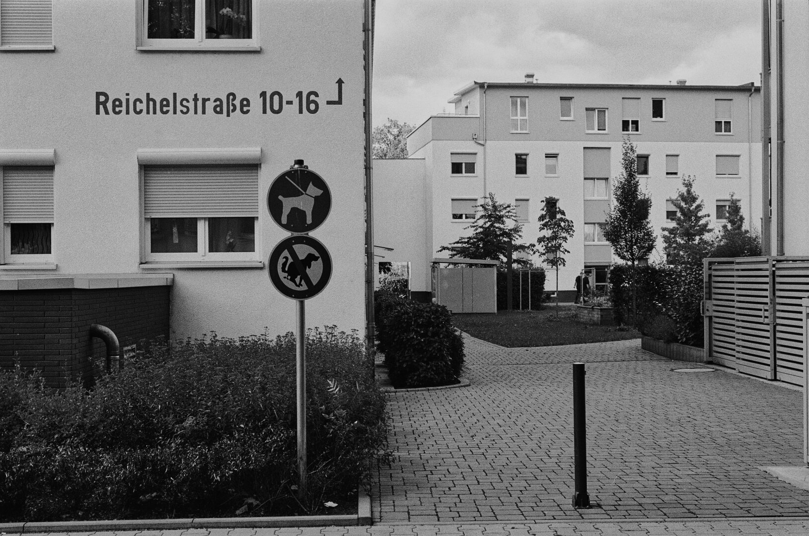 New living area with modern houses at the Reichelstrasse. Two signs let you know that dogs have to be leashed. And that they are forbidden to poo here.