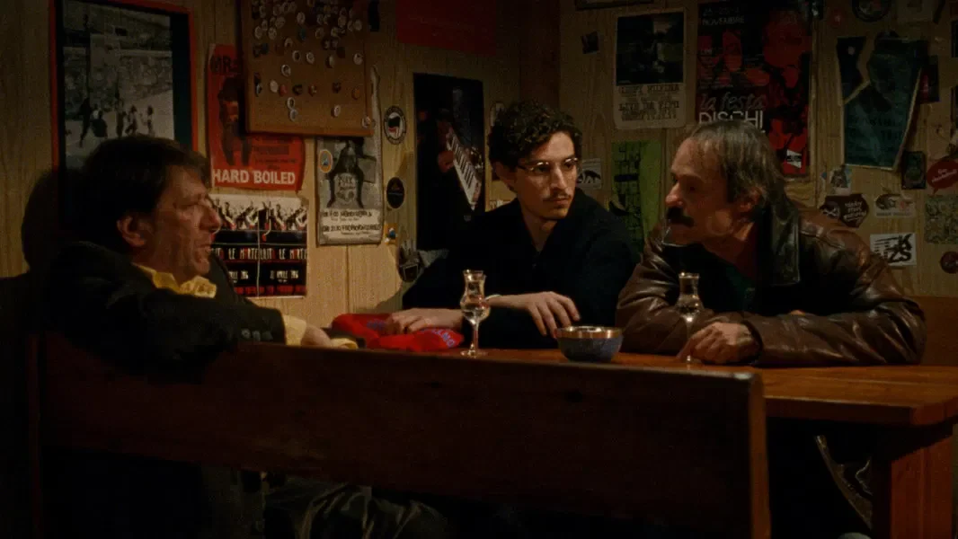 three men sitting at a bar