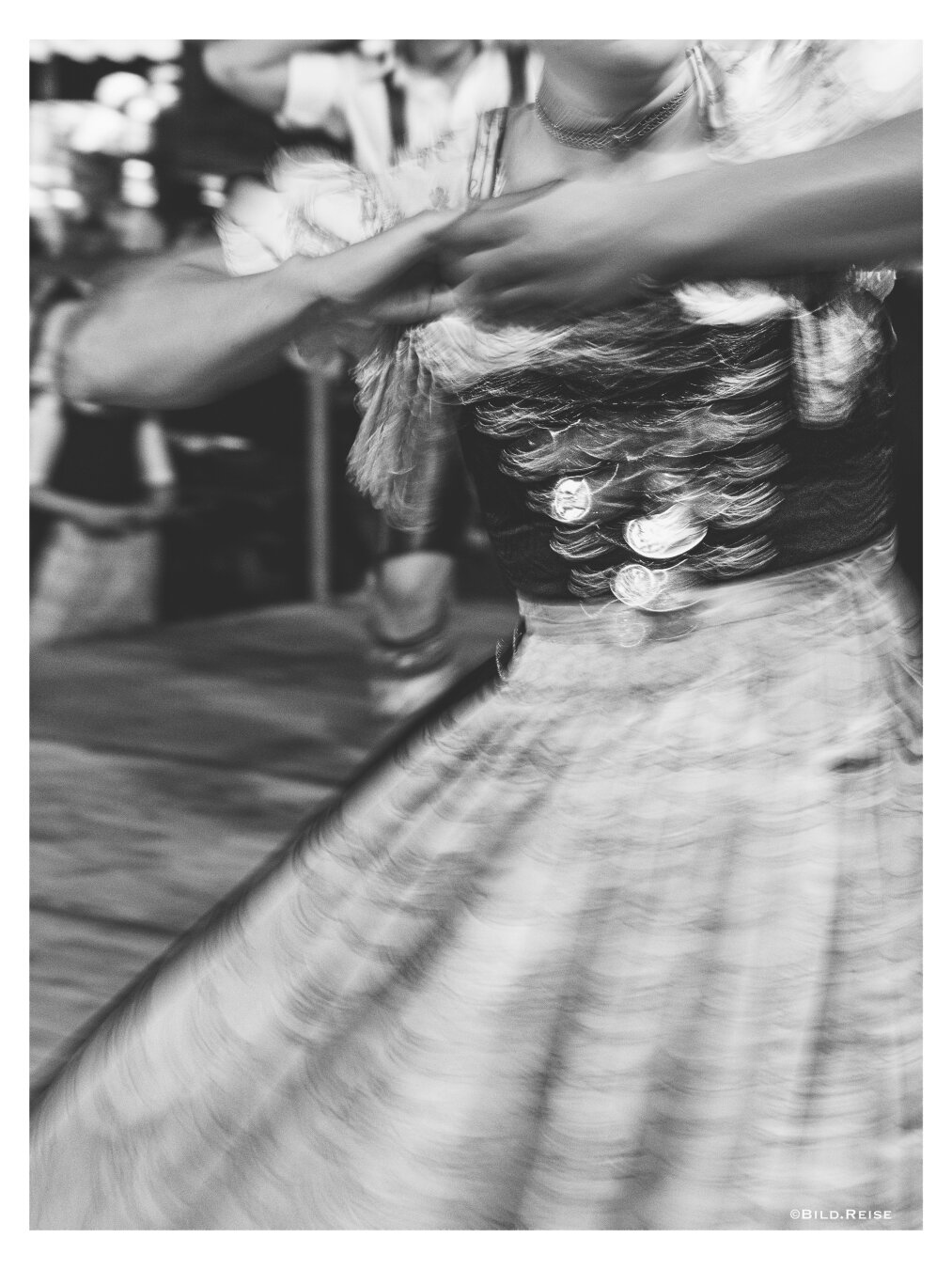 Schwarzweißfoto mit längerer Belichtungszeit einer Dame in bayrischer Tracht.