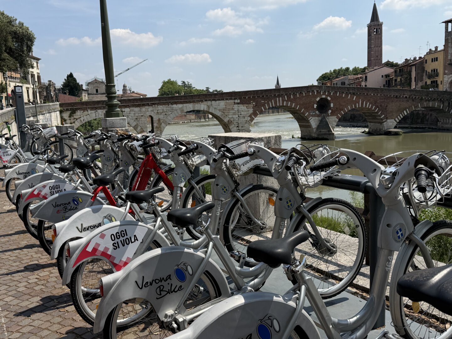 Blick auf Fahrradständer mit geparkten Fahrrädern. Gesehen, direkt bei  der Brücke ‚Ponte di pietra‘ in Verona.

View of a bike rack with parked bicycles. Seen right by the ‘Ponte di Pietra’ bridge in Verona.