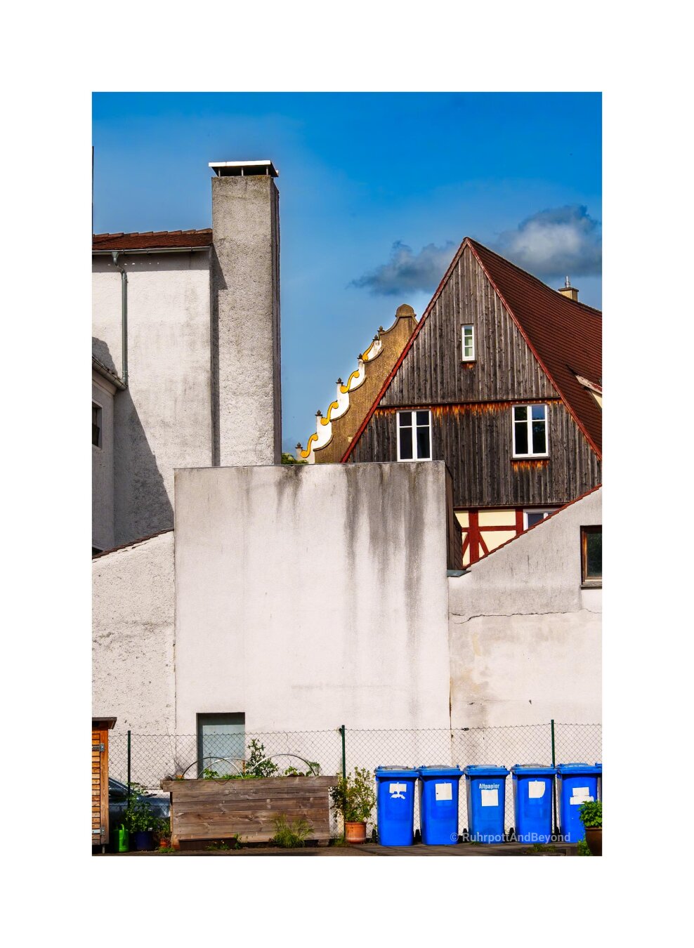 Hinterhof in einer Altstadt. Mülltonnen, Zaun, graue Wände....im Hinteren Teil des Fotos erkennt man aber ein wenig von einem alten prachtvollen Haus.