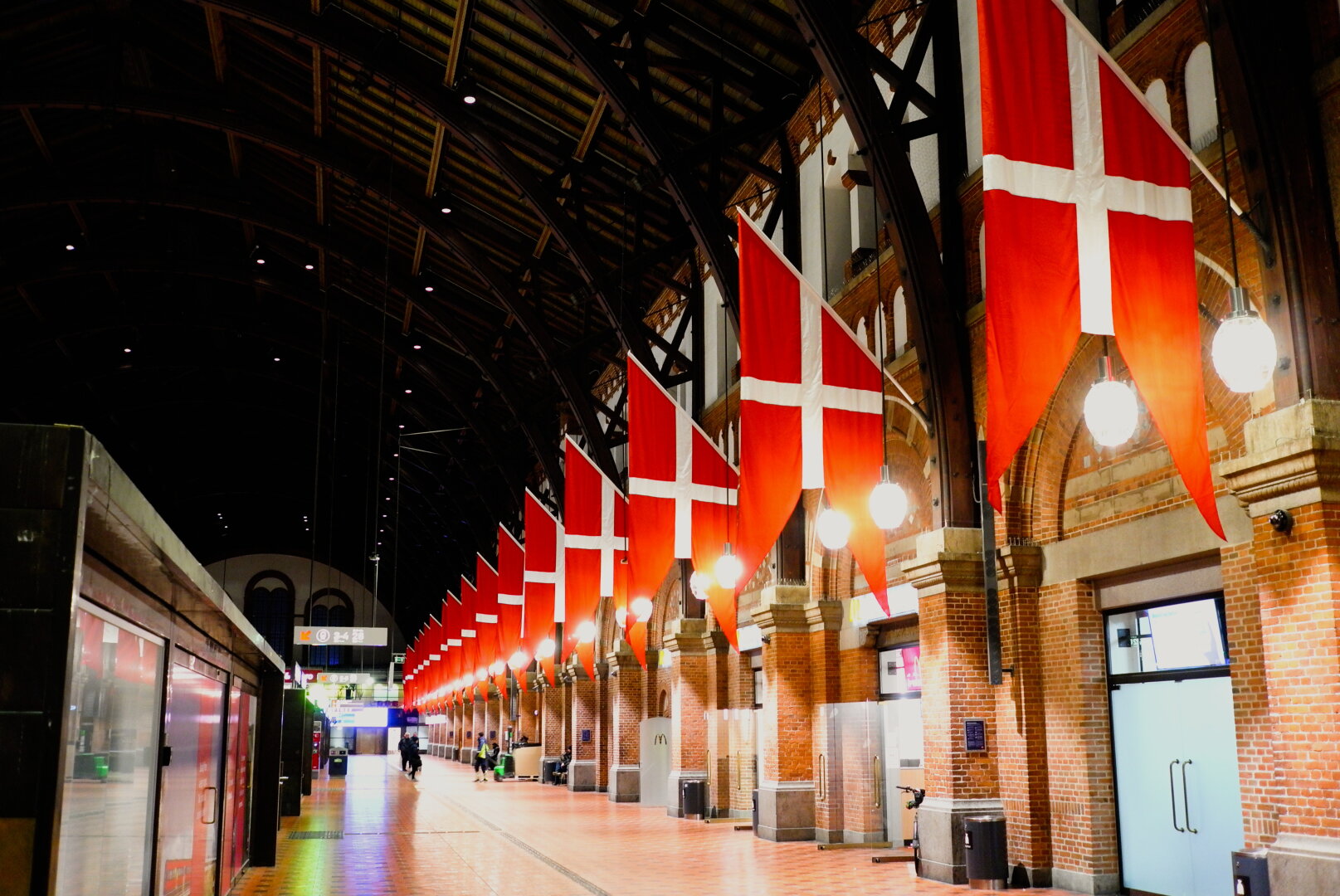 A picture showing a long row of the danish flag , on the central railway station in Copenhagen.
