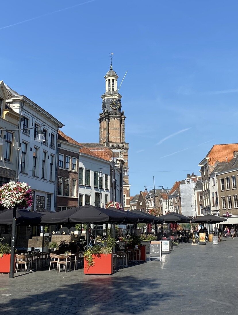 Straat met terrasjes en een kerk op de achtergrond