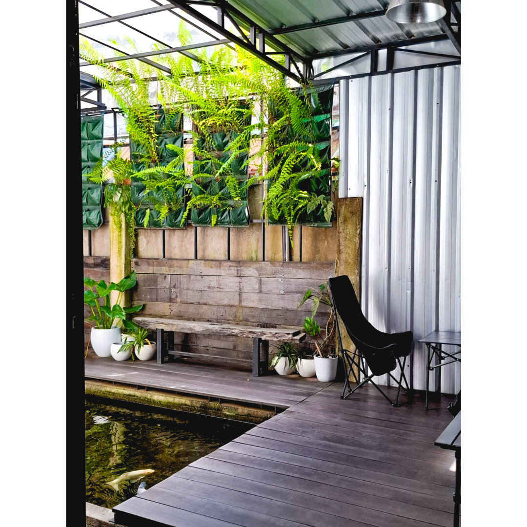 A living room featuring a koi pond and lush greenery.