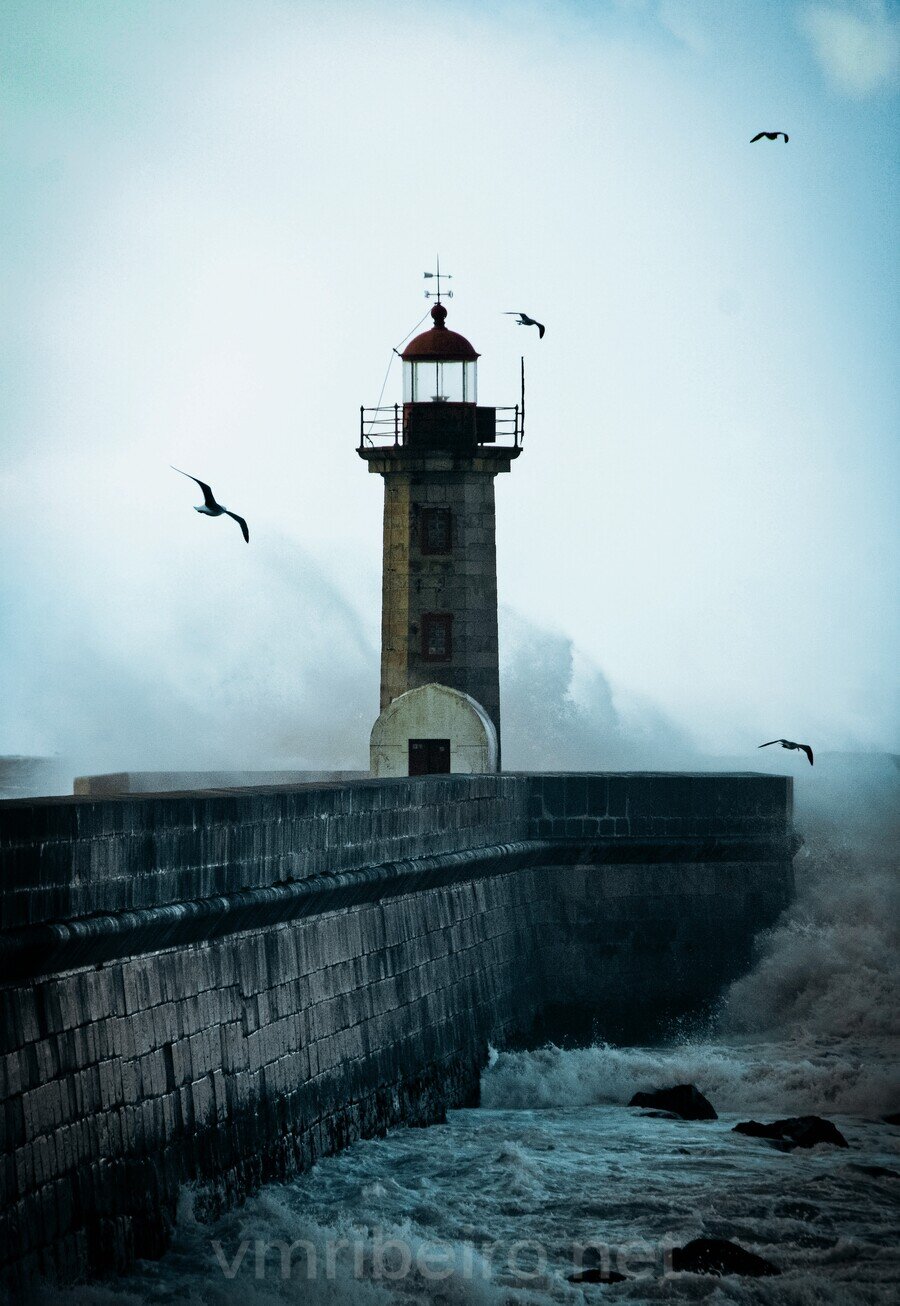 Farolim de Felgueiras na Foz do Douro, no Porto, com o mar a embater no molhe e o farol recortado contra o horizonte.